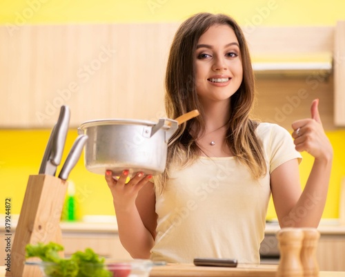 Young woman cooking soup in kitchen at home © Elnur