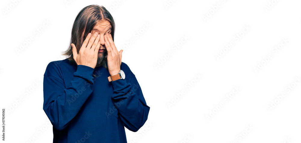 Handsome caucasian man with long hair wearing casual winter sweater rubbing eyes for fatigue and headache, sleepy and tired expression. vision problem Handsome caucasian man with long hair wearing casual winter sweater rubbing eyes for fatigue and headache, sleepy and tired expression. vision problem