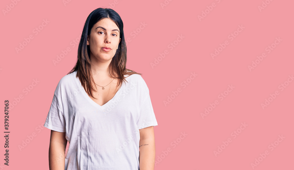 Fototapeta premium Young beautiful brunette woman wearing casual t-shirt relaxed with serious expression on face. simple and natural looking at the camera.