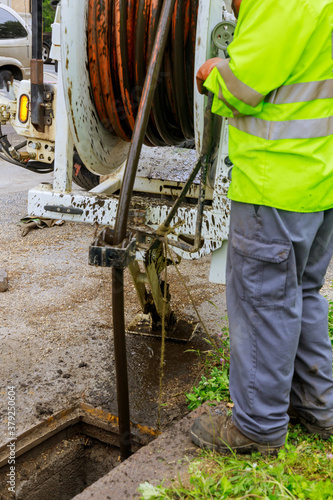 Machine for cleaning sewer wells in the a town street.