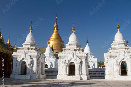 Oranate small white pagodas surrounding a large gold plated pagoda.