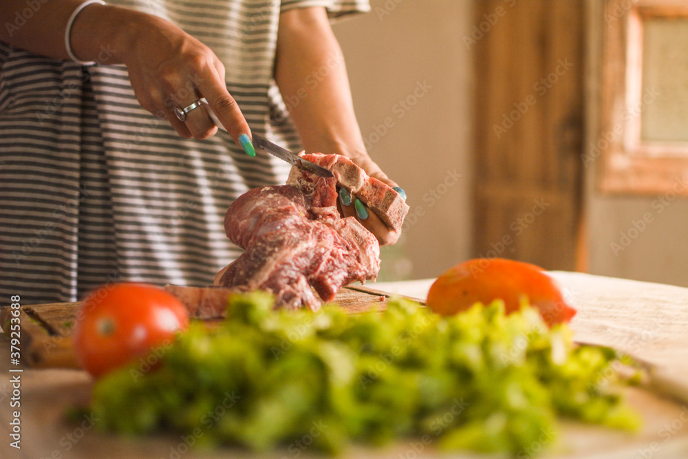 woman cutting meat with a knife, woman preparing lunch