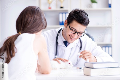 Woman with pet rabbit visiting vet doctor