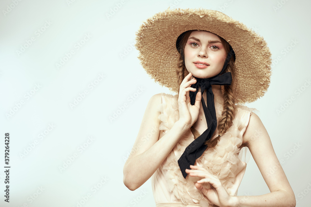 Nice girl in a straw hat with a black ribbon and in a dress on a light background romance model fun emotion Nice girl in a straw hat with a black ribbon and in a dress on a light background romance model fun emotion