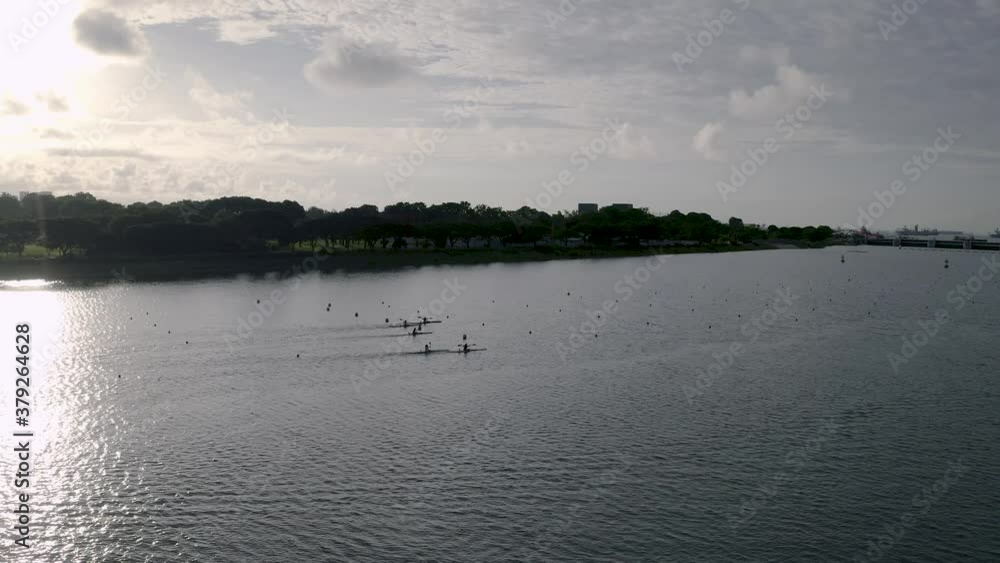 Rotating drone shot of kayakers kayaking at Marina Bay at sunrise (4K).mp4 Rotating drone shot of kayakers kayaking at Marina Bay at sunrise (4K).mp4