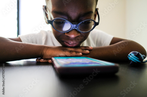 Virtual Education: The New Normal During the Coronavirus Pandemic.  African American boy leaning home with IPhone.. (Photo: Edwine Seymour) photo