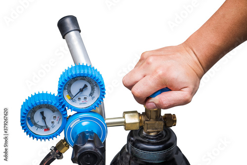 Hand spin off close operating valve of welding equipment acetylene gas cylinder with regulator pressure gauge on the oxygen tank isolated on white background. Maintenance service technical concepts.