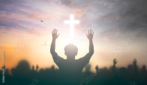 Worship concept: christian people Raise hand over cross on spiritual sky background