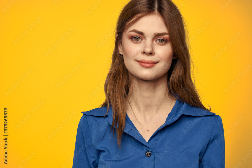 Woman in blue shirt on yellow background portrait close-up red hair model Woman in blue shirt on yellow background portrait close-up red hair model