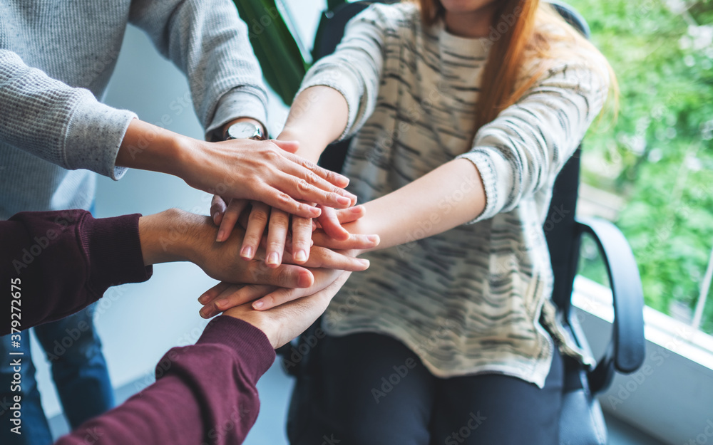 Fototapeta premium Closeup image of business team standing and joining their hands together in office