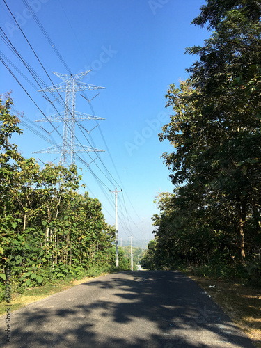 downhill roads and high voltage electric towers in the hills photo