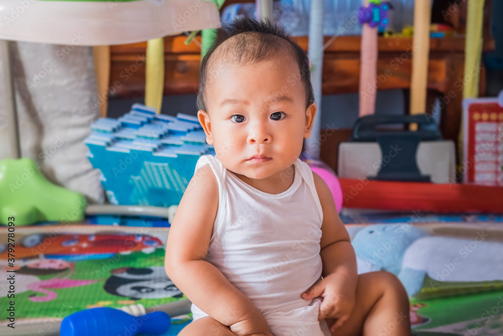 Cute little asian baby boy relaxing and looking up camera in the crib at home. Nursery for young children. Breastfeeding or early childhood development concept Cute little asian baby boy relaxing and looking up camera in the crib at home. Nursery for young children. Breastfeeding or early childhood development concept
