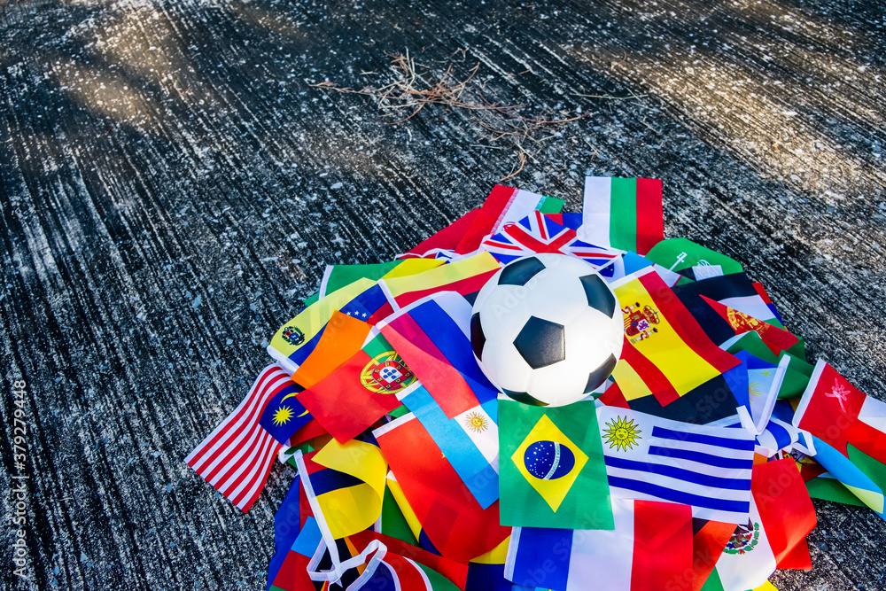 Above view of leather soccer ball on the ground with international team flags of the participating country in the championship tournament.Football equipment to play competitive game.World cup,Top view