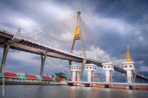 Fotografie The beautiful view floodgate of Bhumibol Bridge during the evening time in Bangkok at Thailand, known as the Industrial Ring Road Bridge over the Chao Phraya River