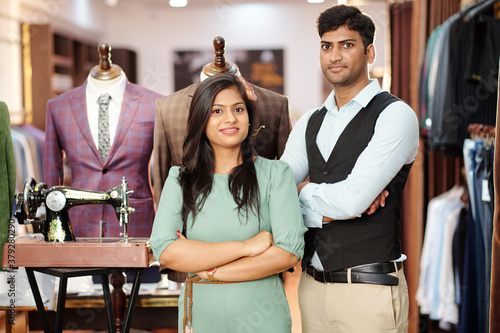 Confident team of young Indian tailors standing in their atelier photo