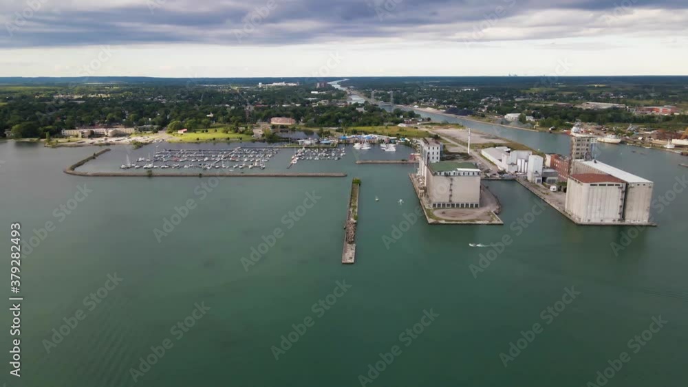 Aerial view of boats entering marina and port facilities on a beautiful green waters of Lake Erie. Aerial view of factories and grain terminal at Sugarloaf Marina in Port Colborne, Canada. Aerial view of boats entering marina and port facilities on a beautiful green waters of Lake Erie. Aerial view of factories and grain terminal at Sugarloaf Marina in Port Colborne, Canada.