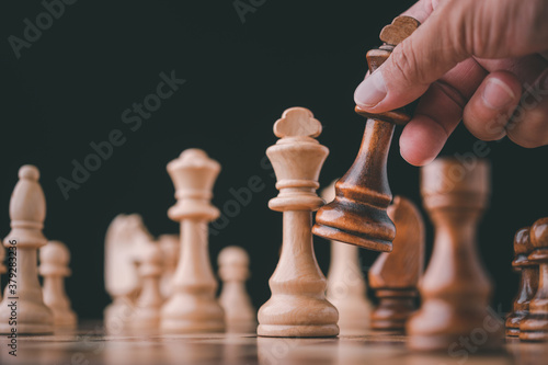 male hand moving chess piece on chess board game concept for ideas and competition and strategy, business success concept, business competition planing teamwork strategic concept.