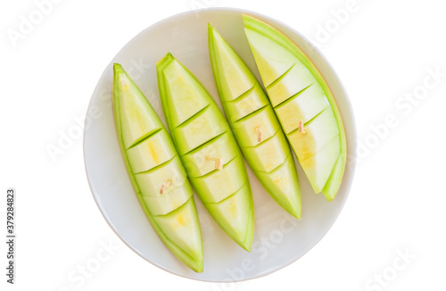 Juicy honeydew melon in dish isolated on white background. Top view