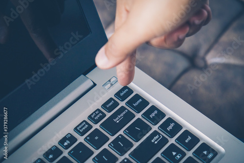 Fotografie Closeup image of finger pushing button delete data on the laptop computer