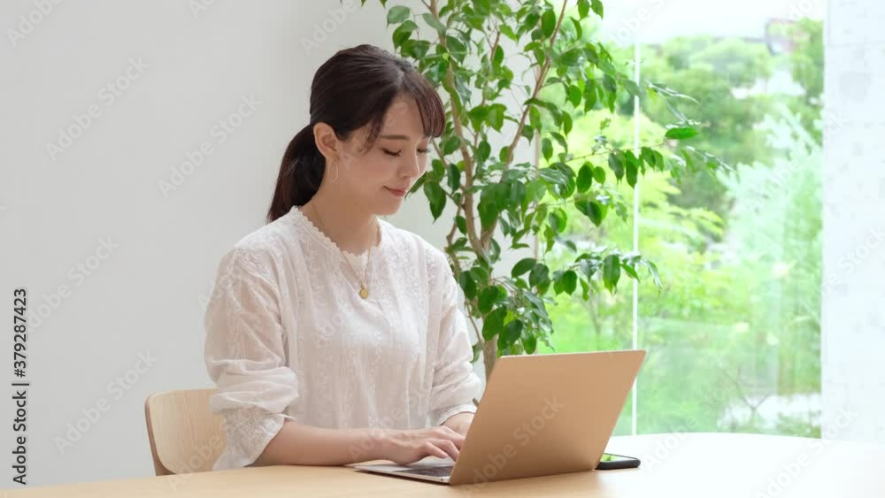 リビングでパソコンを使う女性 リビングでパソコンを使う女性