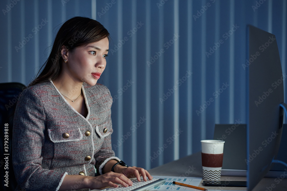 Young pretty Vietnamese businesswoman drinking take away coffee when working at office all day long and finishing big project within deadline Young pretty Vietnamese businesswoman drinking take away coffee when working at office all day long and finishing big project within deadline