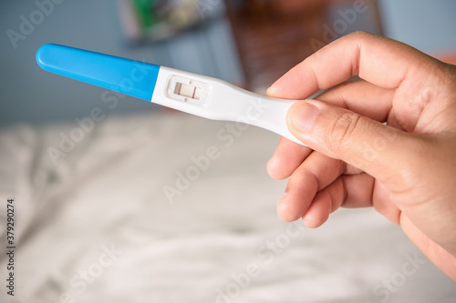 Young woman happy holding after positive pregnancy test.