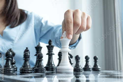 The hands of businesswomen moving chess in chess competitions demonstrate leadership, followers, and strategic plans, business success building processes, and teamwork