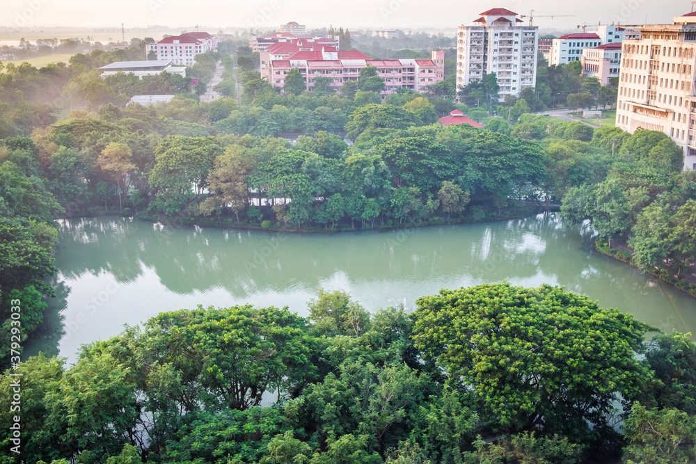 Fototapeta premium The aerial view of lake in green forest during summer day at Nakhon Nayok Province, Thailand.