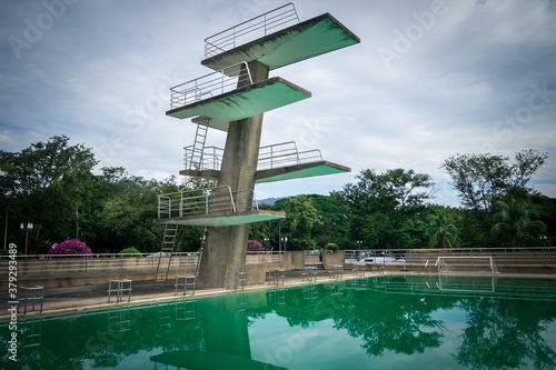 View of diving board on blue sky at Thailand. This photo can be used for sport concept. Public plunge pool.