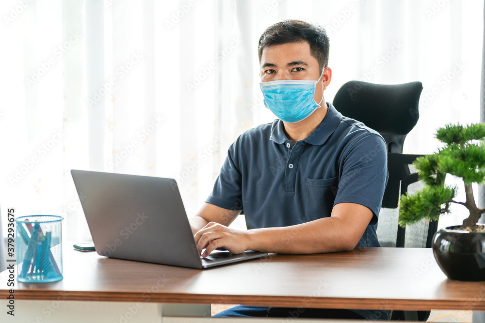 quarantine, asian man wearing face protective medical mask for protection from virus disease with laptop computer working at home, Concept of technology communication quarantine, asian man wearing face protective medical mask for protection from virus disease with laptop computer working at home, Concept of technology communication