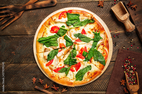 Top view on pizza napoli with spinach and tomatoes