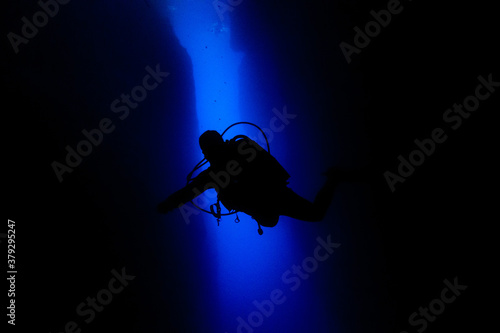 Scuba diver black silhouette in a blue canyon