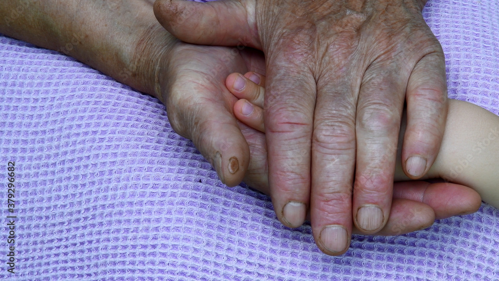 Wrinkled granny hands hold kid hand between. Care concept Wrinkled granny hands hold kid hand between. Care concept