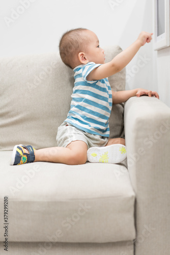 A baby boy of one and a half years old is playing in the room