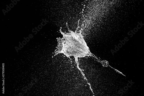 Throwing of dart in balloon with water on dark background