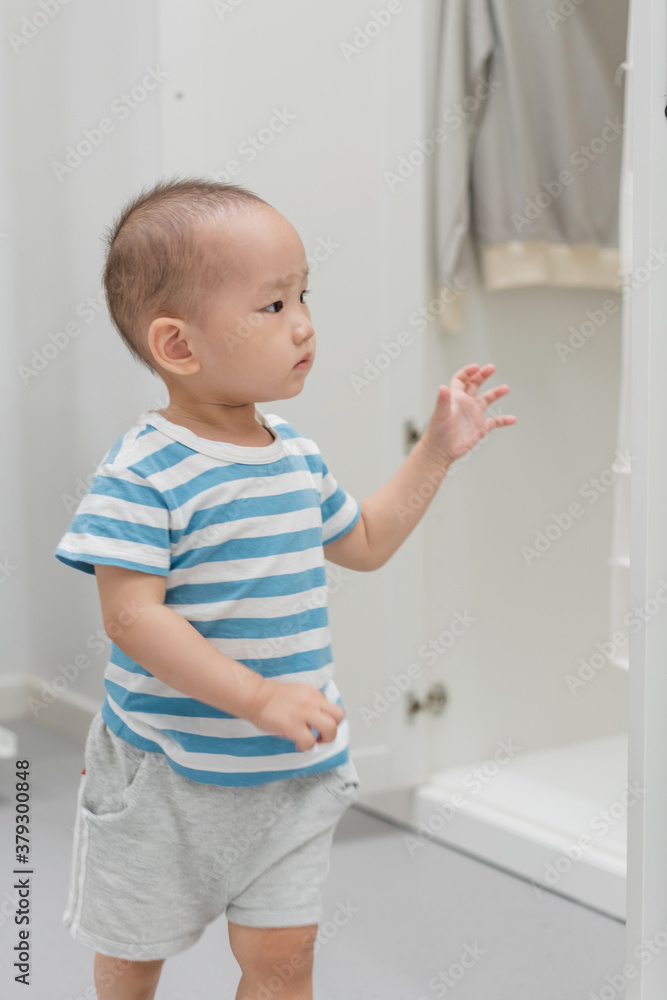 A baby boy of one and a half years old is playing in the room