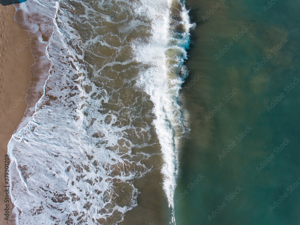 Aerial view of blue sea, waves and beach.