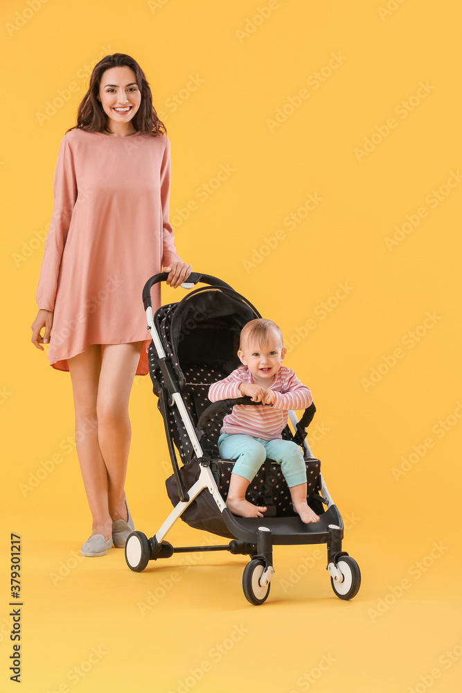 Woman and her cute baby in stroller on color background Woman and her cute baby in stroller on color background
