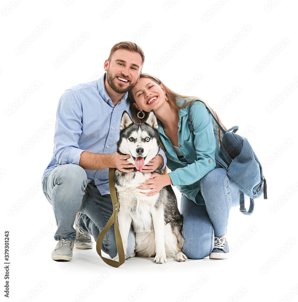 Young couple with cute Husky dog on white background