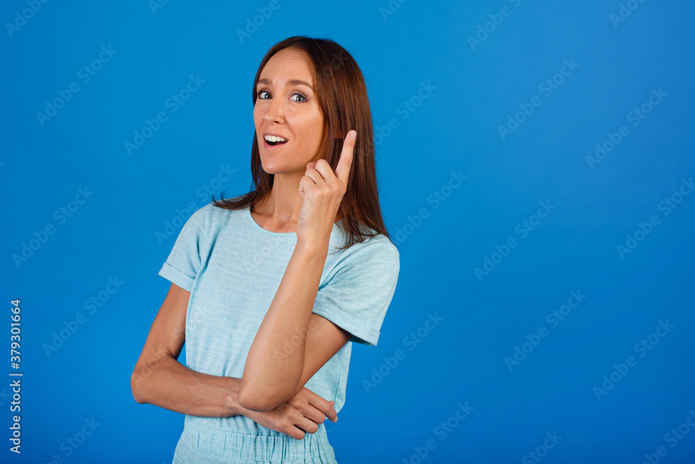 Image of happy young lady standing isolated over blue background. Looking camera pointing. Image of happy young lady standing isolated over blue background. Looking camera pointing.
