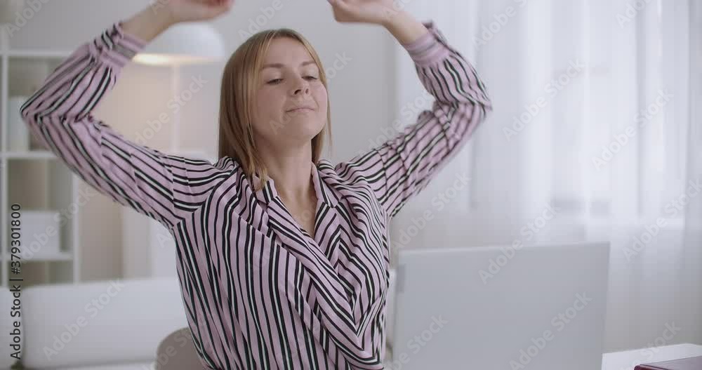 tired student woman is learning in home, sitting at table and writing, stretching hands up, relaxing back tired student woman is learning in home, sitting at table and writing, stretching hands up, relaxing back