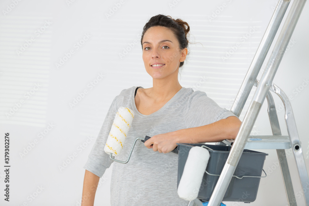 beautiful young slim builder girl holding paint roller beautiful young slim builder girl holding paint roller