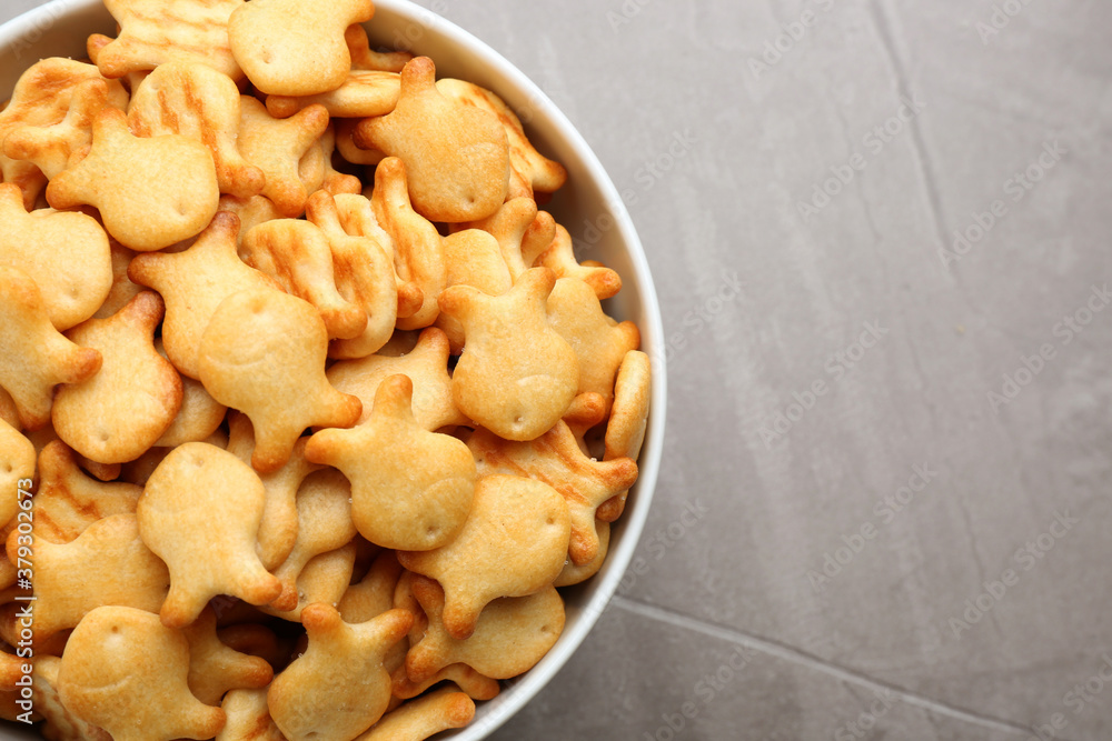 Delicious goldfish crackers in bowl on grey table, top view Delicious goldfish crackers in bowl on grey table, top view
