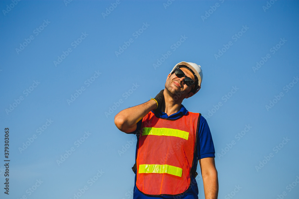 Factory worker holding painful shoulder with another hand, young man with neck pain Factory worker holding painful shoulder with another hand, young man with neck pain