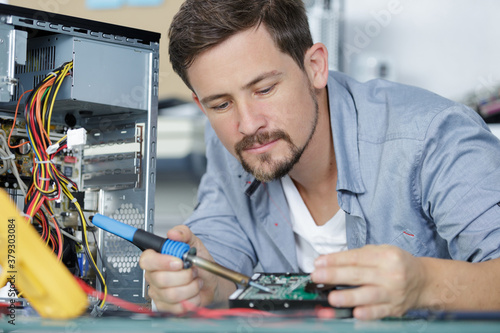 Wallpaper Mural handsome man soldering a circuit board Torontodigital.ca