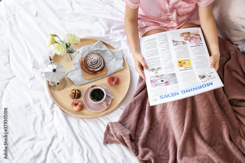 Young woman reading newspap...