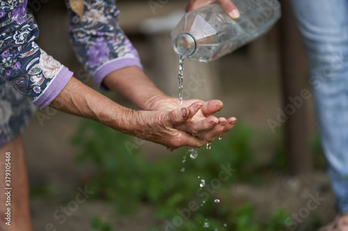 Old woman farmer wasing her hands