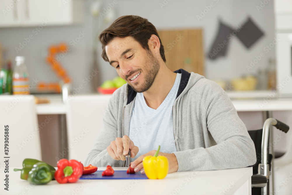 disabled man in wheelchair cutting vegetables at home disabled man in wheelchair cutting vegetables at home
