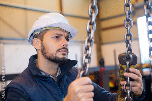 young metalworker hooks a steel tube to lift