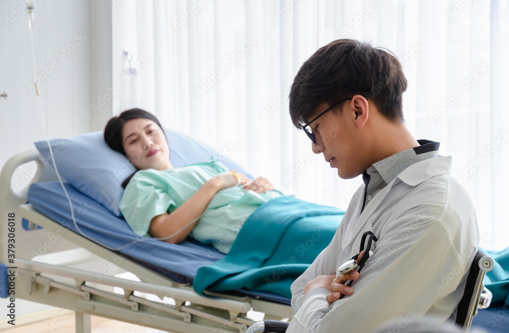 Tired Doctor in white uniform napping at hospital ward for caring patient. Tired Doctor in white uniform napping at hospital ward for caring patient.